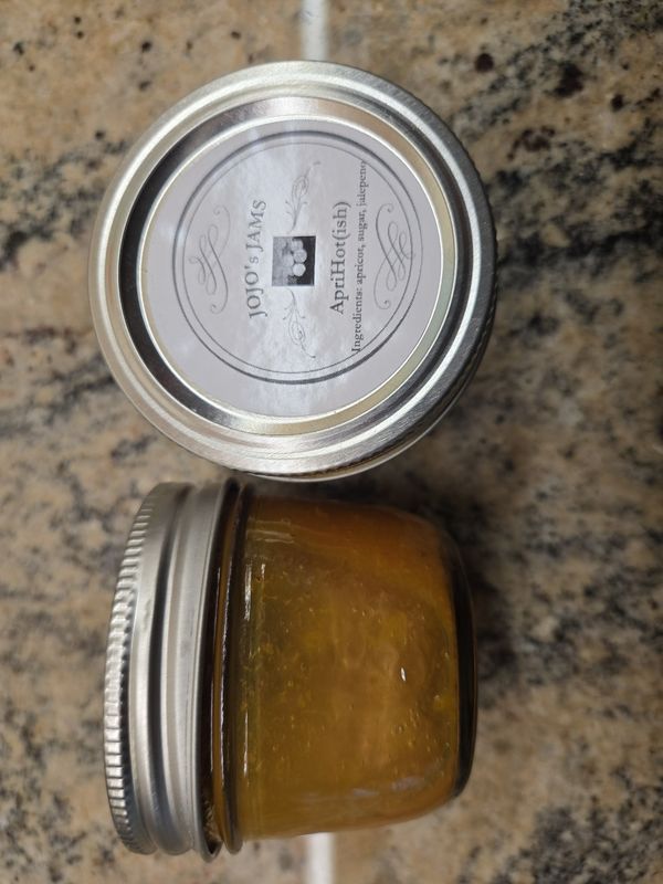 A pot of JoJo's ApriHot jam with its label