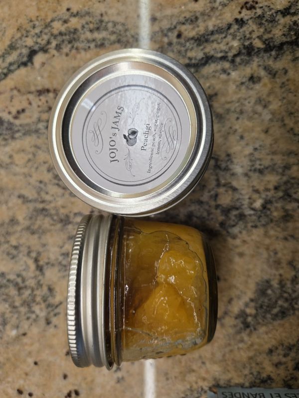 A pot of JoJo's PeachGi jam with its label