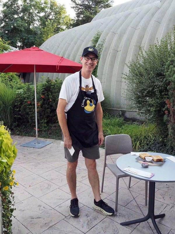 Mark Gibson smiling in his Cheese Tango apron at the winery patio