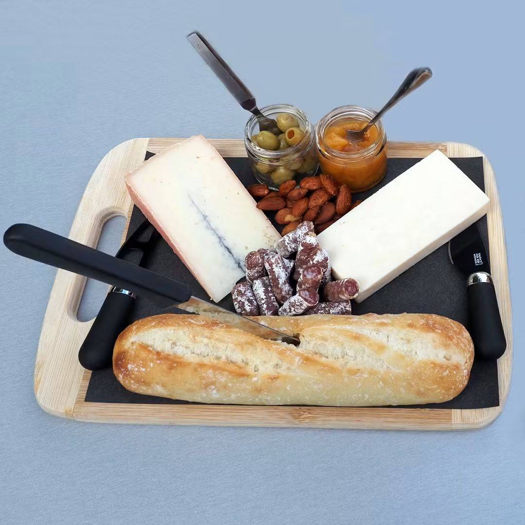A build-your-board charcuterie spread with cheese, cured meats, baguette, olives, almonds and jam
