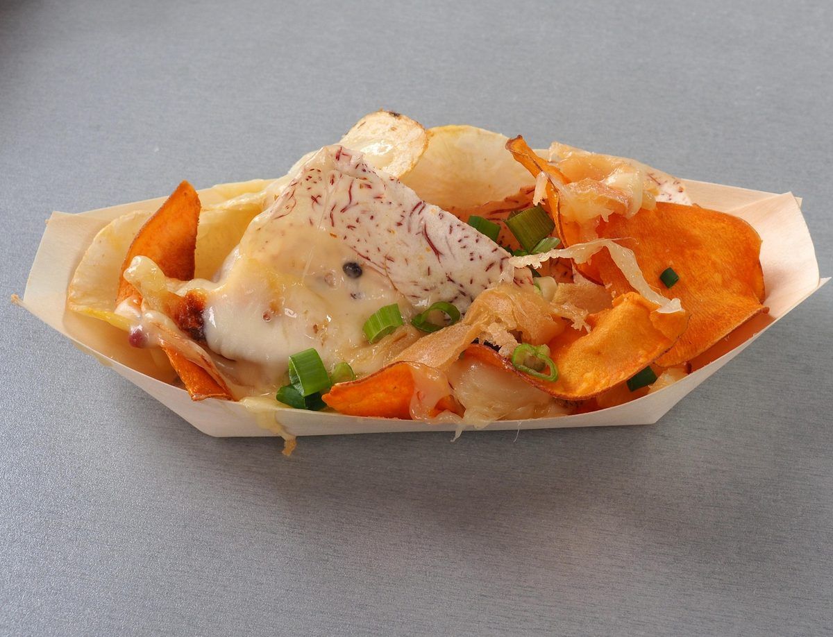 Chiplette: gourmet chips topped with molten raclette and green onions in a paper tray